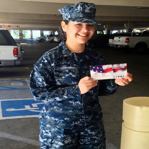 Smiling service member in military uniform holding a free calling card.