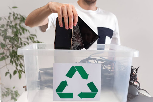 Person sorting and packaging recycled cell phones for processing