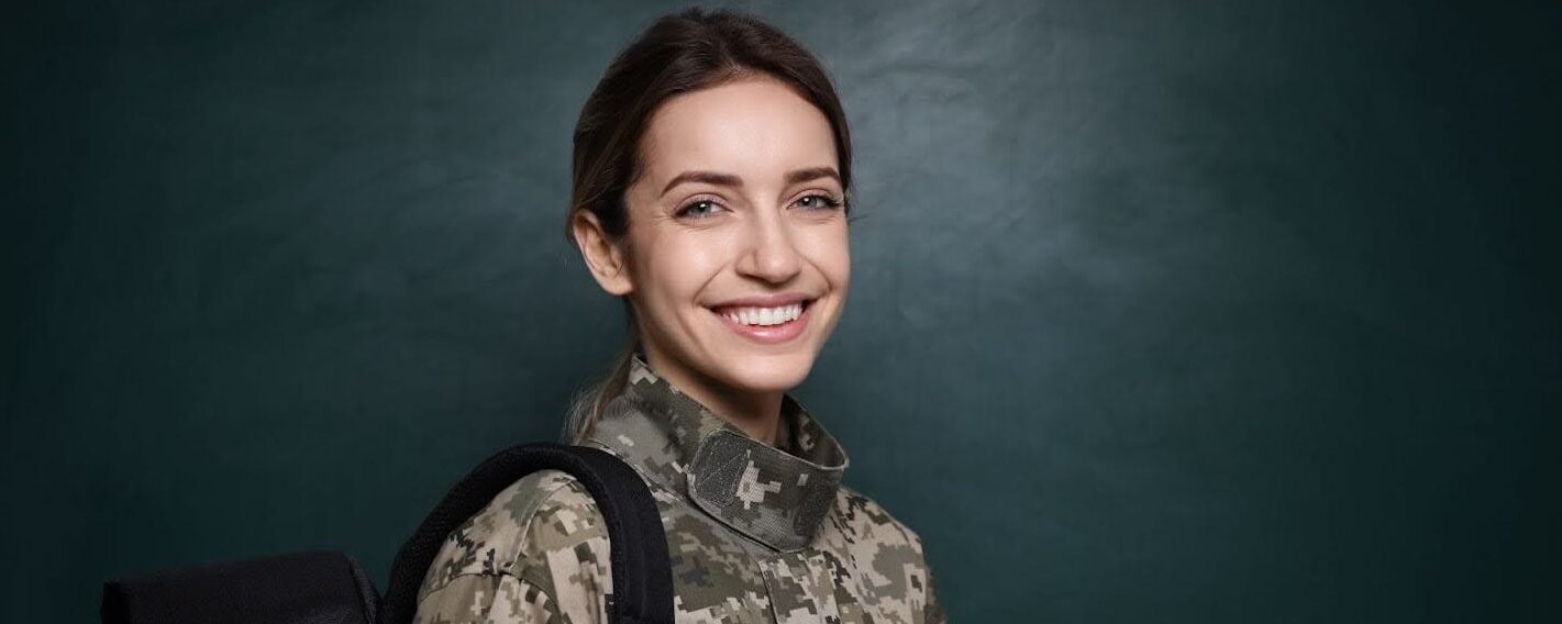 Female veteran with laptop and backpack, smiling & appreciative of higher education financial support